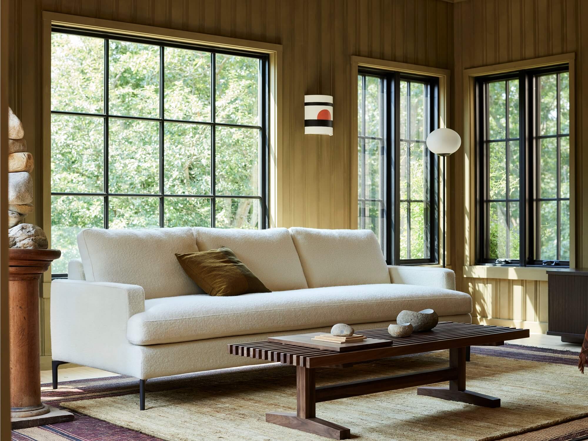 Green mid century couch in bright wood paneled living space